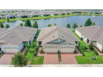 Charming single-story home boasts lush landscaping, brick driveway, and a picturesque waterfront view for serene living at 17597 Summersweet Way, Clermont, FL 34714