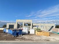 New construction of a modern home showcasing concrete block walls and prepped lumber under a bright blue, partially cloudy sky at 2710 Ravencliffe Ter, Oviedo, FL 32765