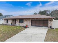 Brick ranch home with attached garage and landscaped lawn at 2752 Sedgefield Ave, Deltona, FL 32725