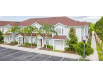 Light-blue townhouses with red roofs, palm trees, and a walkway at 3201 Gold Ln, Kissimmee, FL 34747