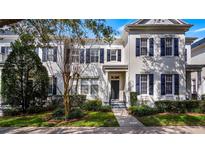 White two-story townhome with dark shutters and a manicured lawn at 5419 Baldwin Park St, Orlando, FL 32814