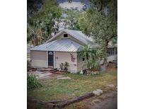 Tan house with metal roof, American flag, and landscaping at 590 W Vine St, Bartow, FL 33830