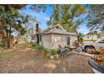 Tan house exterior with mature trees and a spacious yard at 590 W Vine St, Bartow, FL 33830