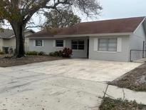 House exterior features a gray painted exterior, a large driveway, and mature landscaping at 610 Thomas Ave, Winter Haven, FL 33880