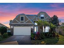 Two-story house with stone accents and a three-car garage,solar panels,landscaped yard at 820 Spring Oak Cir, Orlando, FL 32828