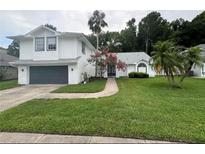 Two-story house with white siding, gray garage door, and landscaped lawn at 862 Shriver Cir, Lake Mary, FL 32746