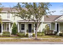 Two-story light green house with a front porch and landscaping at 14531 Clarkson Dr, Orlando, FL 32828