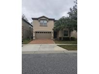 Two-story house with a brown brick driveway and palm trees at 1662 Lima Ave, Kissimmee, FL 34747