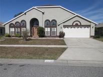 Two-story house with a large driveway and landscaped yard at 265 Kassik Cir, Orlando, FL 32824