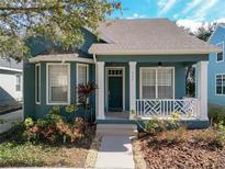 Charming teal house with a white porch and well-manicured landscaping at 333 N Forest Ave, Orlando, FL 32803