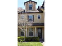 Inviting townhouse featuring neutral-toned facade, manicured landscaping, and well-lit windows at 7387 Duxbury Ln, Winter Garden, FL 34787