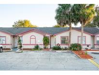 Front view of charming condo with pink accents and landscaping at 810 Christian Way, Kissimmee, FL 34741