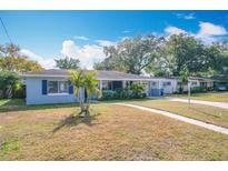 Light blue house with palm trees, walkway, and driveway at 1930 Albert Lee Pkwy, Winter Park, FL 32789