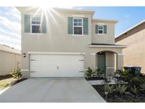 Two-story house with a white garage door and green shutters at 2630 Angel Falls Dr, Davenport, FL 33837