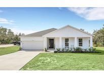 White farmhouse exterior with a front porch and grassy yard at 39641 Royal Trails Rd, Eustis, FL 32736