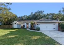 Cute ranch home with a well-manicured lawn, attached garage, and mature trees at 853 E 20Th St, Sanford, FL 32771