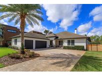 Beautiful home with an elegant driveway, a three-car garage, stone accents, and lush landscaping at 10416 Pocket Ln, Orlando, FL 32836