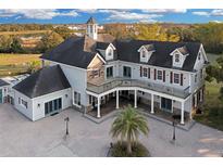 Stunning multi-story home with a large porch, beautiful landscaping, and a circular driveway at 1730 Connecticut Ave, St Cloud, FL 34769