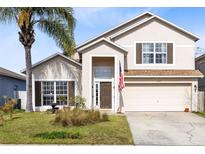 Two-story house with tan exterior, brown shutters, and a two-car garage at 290 Clydesdale Cir, Sanford, FL 32773