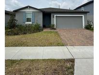 Charming single-story home with brick driveway, well-maintained landscaping, and a two-car garage at 3072 Cassidy Ln, Haines City, FL 33844