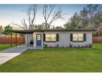 Newly renovated home with carport, modern facade, and manicured lawn at 4722 Halliday Ln, Orlando, FL 32810