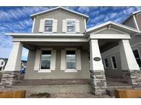 Two-story home with gray siding, stone accents, and a covered porch at 5306 Center Lake Ranch Blvd, St Cloud, FL 34771