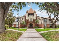 Unique condo building featuring brick and Tudor-style architecture with turrets and lush landscaping at 5413 Hansel Ave # K10, Orlando, FL 32809