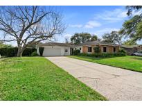 Charming single-story home with lush landscaping, long driveway, and an attached two-car garage at 630 Marshall St, Altamonte Springs, FL 32701