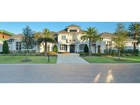 Stunning two-story home boasts a balcony, lush landscaping, and a grand brick driveway at 7017 Via Carmel Way, Orlando, FL 32819