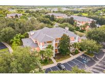 Aerial view of a two-story condo building with ample parking at 114 Watling Way # 114, Davenport, FL 33897