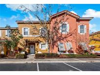 Charming multi-colored townhome featuring a red tile roof, well-maintained landscaping and a welcoming entryway at 136 Pompano Beach Dr, Kissimmee, FL 34746