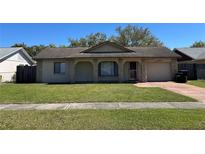 Charming single-story home with stone accents, an arched entryway, and a well-maintained front yard at 3303 Jon Jon Dr, Orlando, FL 32822