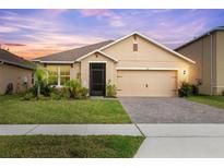 Charming single-story home featuring a well-manicured lawn, a two-car garage, and lovely landscaping at 523 Lazio Cir, Debary, FL 32713
