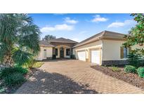 Charming home featuring a paved driveway, beautiful landscaping, and a three-car garage at 5400 Emerald Bay Ln, Lady Lake, FL 32159
