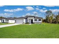 Newly constructed home with a spacious lawn and attached garage at 13497 Se 100Th Ave, Belleview, FL 34420