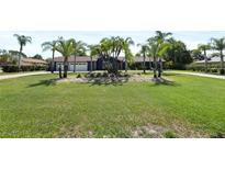 Blue house with palm trees and a manicured lawn at 1877 Crowley E Cir, Longwood, FL 32779