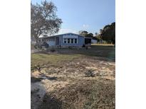 Charming single-story home with light-blue siding, a well-kept lawn, and an attached garage at 357 Wade Park Ct, Davenport, FL 33897