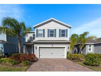 Two-story home with gray siding, shutters, and a two-car garage at 3888 Crawley Down Loop, Sanford, FL 32773