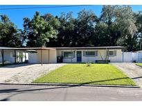 Updated home with carport, fenced yard, and well-manicured lawn at 6601 Harvey St, Orlando, FL 32809