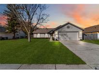 Single-story house with a two-car garage and spacious lawn at 8024 Lesia Cir, Orlando, FL 32835