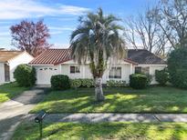Single-story home with red tile roof, landscaping, and driveway at 10107 Musket Ln, Orlando, FL 32821