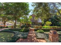 Brick house with a metal roof, lush landscaping, and a brick walkway at 140 Dana Way, Winter Park, FL 32789