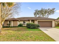 One-story house with brown roof, attached garage, and well-maintained lawn at 2712 Ceram Ave, Orlando, FL 32837