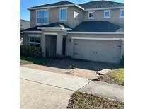 Two-story house with a large driveway and attached garage at 445 Kestrel Dr, Groveland, FL 34736