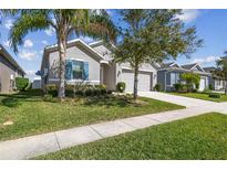 Charming single Gathering home features a well-manicured lawn, neutral paint, and an attached two car garage at 782 Grand Hilltop Dr, Apopka, FL 32703