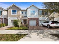 Two-story townhome with brick facade and attached garage at 1055 Taramundi Dr, Oviedo, FL 32765
