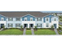 New townhomes with blue and white exteriors, landscaped lawns, and inviting entrances at 107 Jetty Way, Davenport, FL 33897