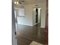 Bright living room with wood-look floors and access to kitchen at 11568 Westwood Blvd # 1034, Orlando, FL 32821
