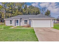 Charming single-story home with a two-car garage and well-maintained lawn in a serene neighborhood at 43 Water Track Dr, Ocala, FL 34472