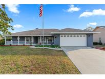 Charming single Gathering home featuring a two car garage, manicured lawn and inviting front porch at 657 Hunters Run Blvd, Lakeland, FL 33809
